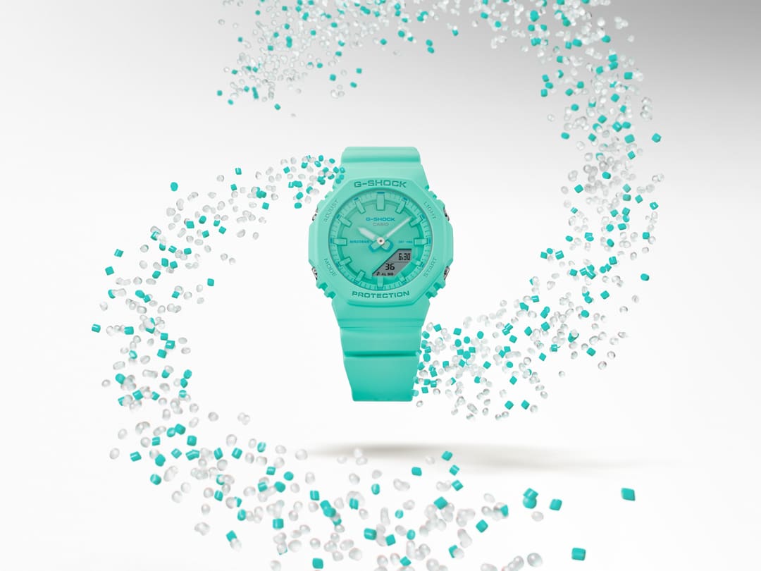 El reloj de mujer Casio G-Shock GMA-P2100-2A de color turquesa rodeado de gránulos de resina transparente y turquesa