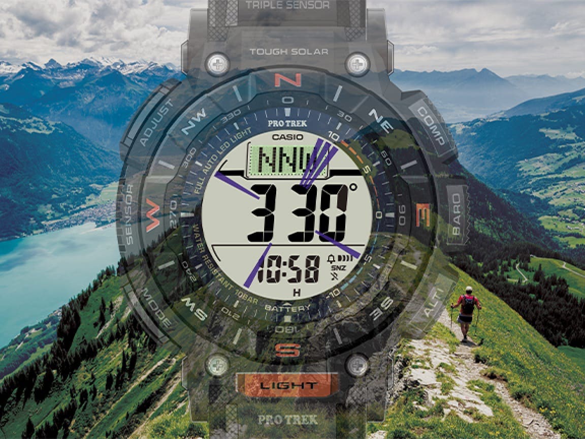 La pantalla del PRG-340-1 muestra datos de la brújula, con alguien caminando por una cima verde al fondo