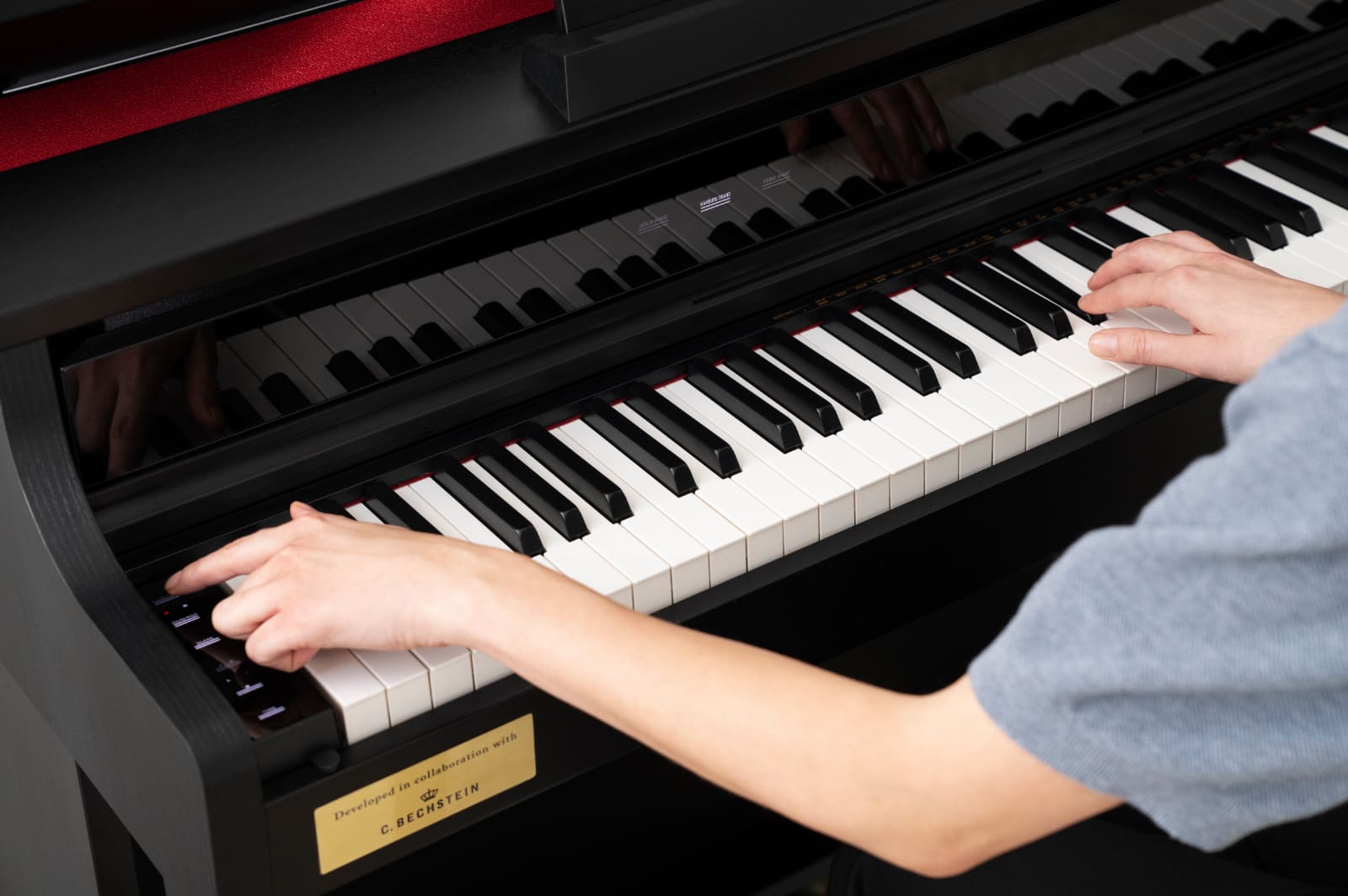 Una persona está sentada al piano digital CASIO AP-750 tocando el piano