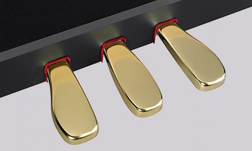 Primer plano de tres pedales dorados de un piano digital negro