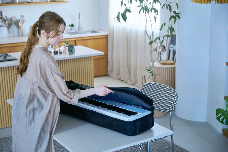 Una imagen de una persona colocando el piano en el estuche.