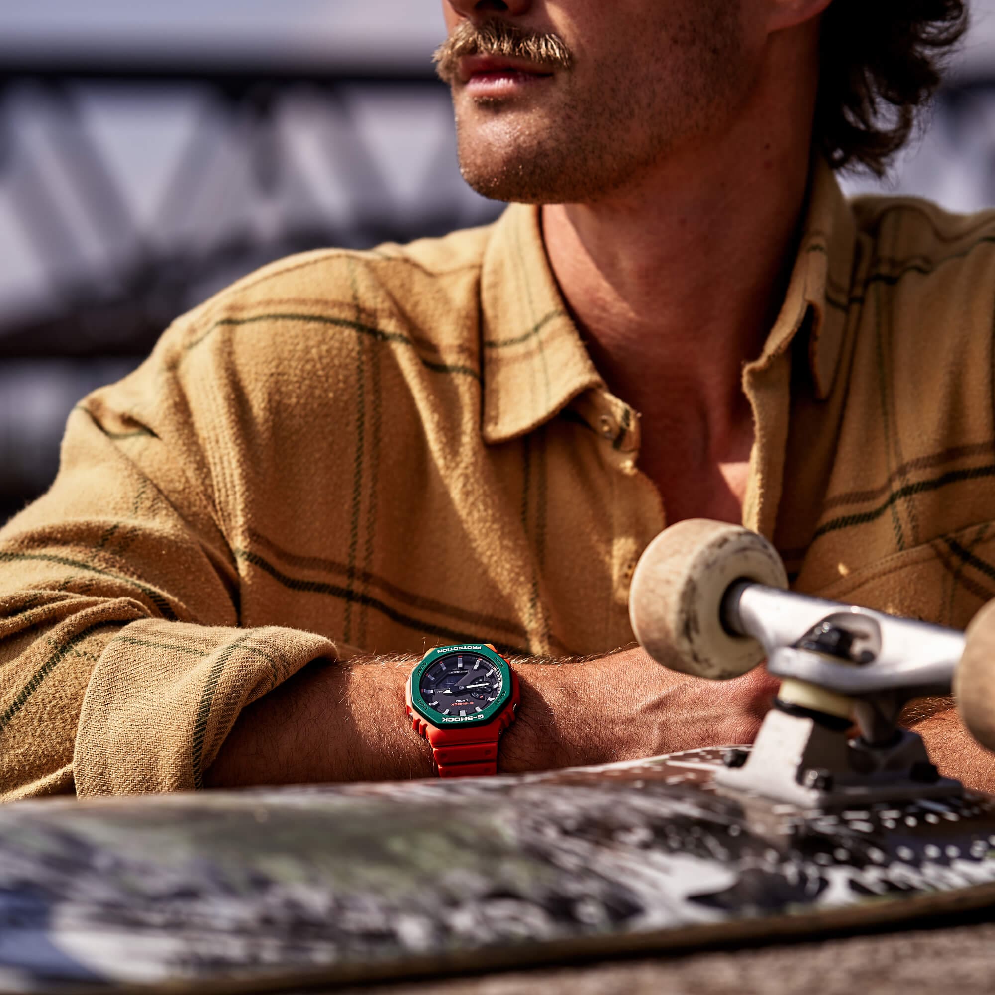 Primer plano: un hombre con el G-SHOCK GA-2110 SC-4A, con un monopatín delante.