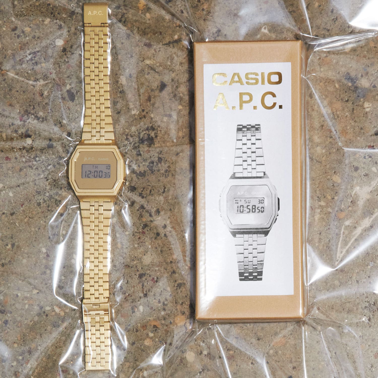La montre-bracelet dorée A1000ACG-9 est posée à côté de la boîte d'emballage