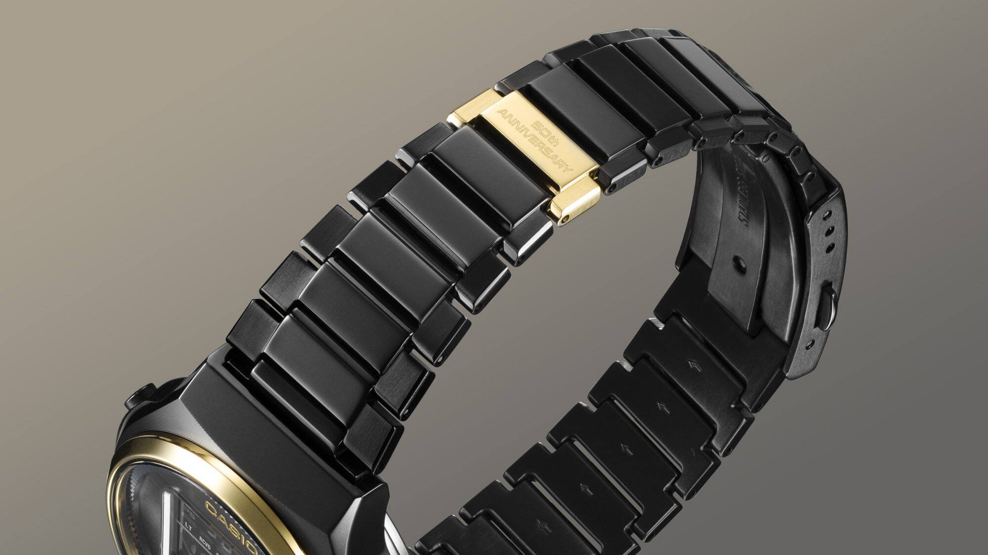 Détail du bracelet à maillons en acier inoxydable noir et brillant avec un seul maillon en or gravé : 50th Anniversary