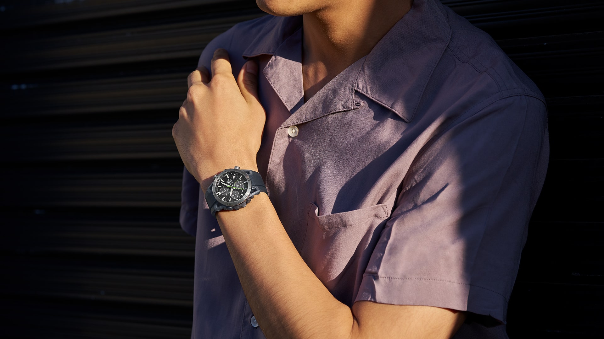 Une montre Casio Edifice EQS-960 au poignet d'un homme portant une chemise lilas.