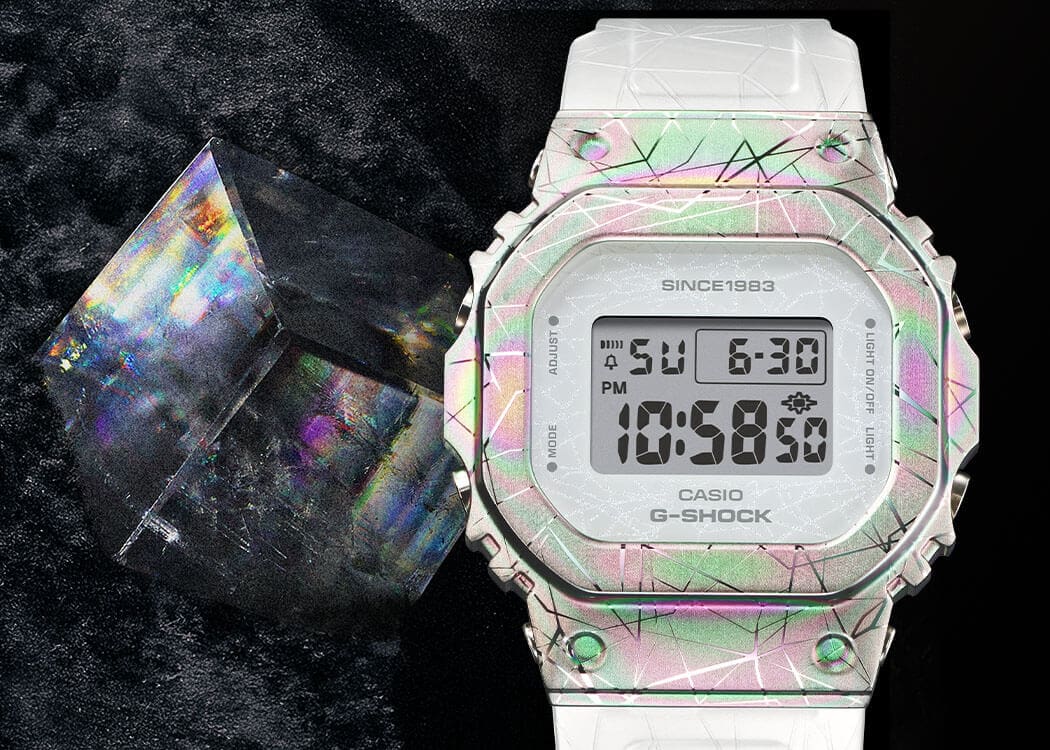 GM-S5640GEM-7 La montre anniversaire GM-S5640GEM-7, d'un blanc chatoyant, à côté d'un cristal de calcite étincelant