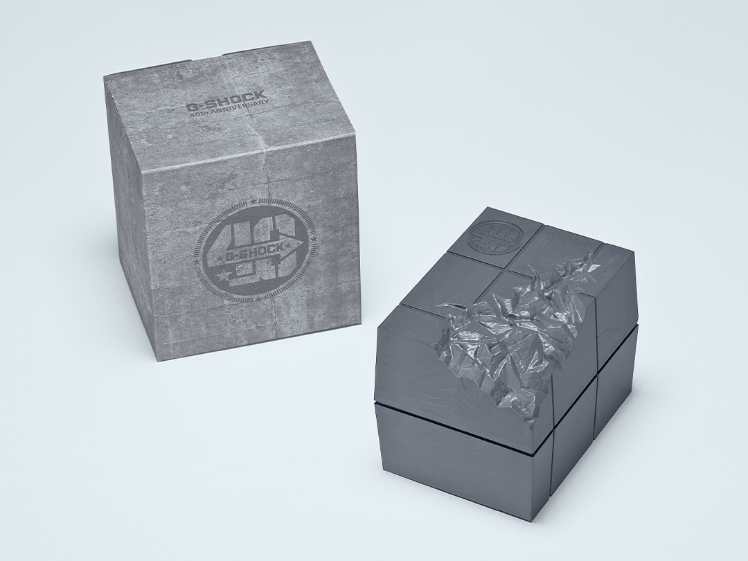 L'emballage gris à côté du coffret spécial au design anniversaire