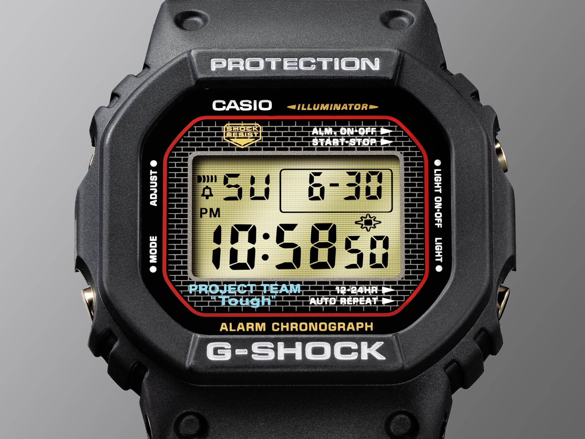 Gros plan sur l'écran de la montre anniversaire Casio G-Shock DW-5040PG-1 noire avec cadre en brique autour de l'affichage numérique