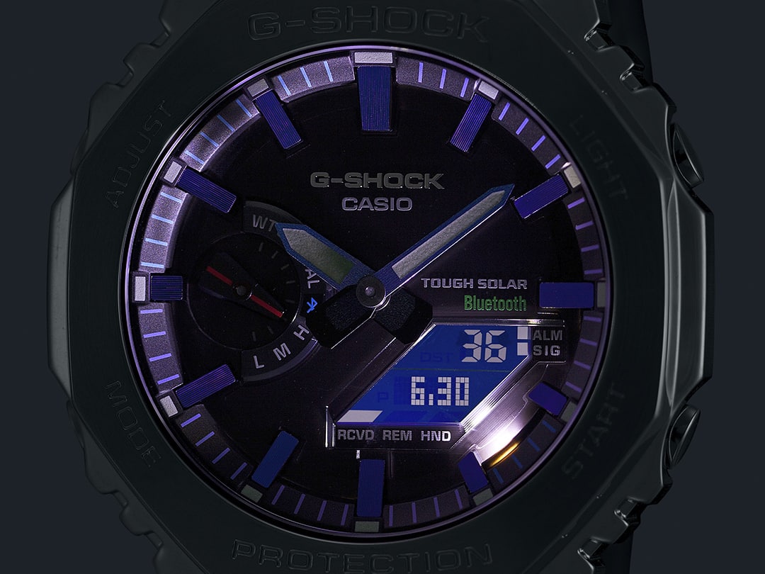 Une montre solaire Casio GM-B2100PC-1A dans l'obscurité avec un cadran illuminé.