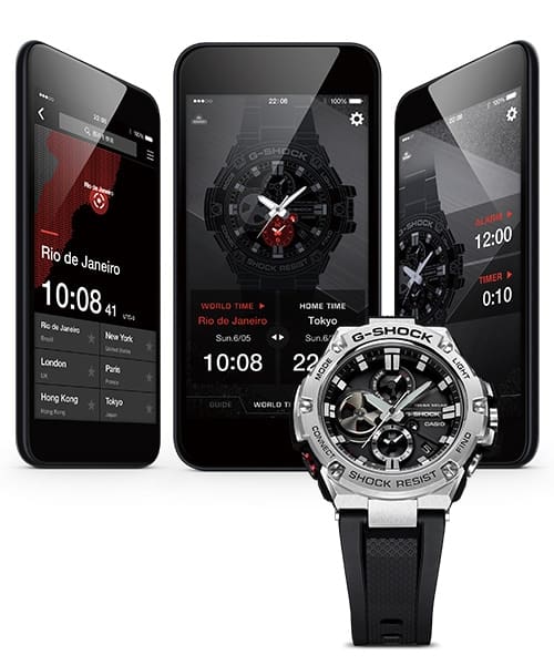 Trois smartphones avec différents écrans d'application G-Shock-Connected, devant une montre-bracelet Casio G-Steel GST-B100 avec bracelet et cadran noirs et boîtier en acier inoxydable argenté.