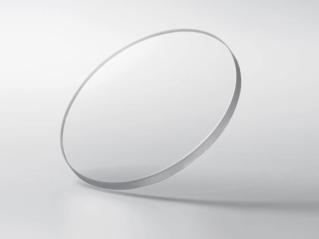 Un disque rond en verre saphir sur un fond gris clair