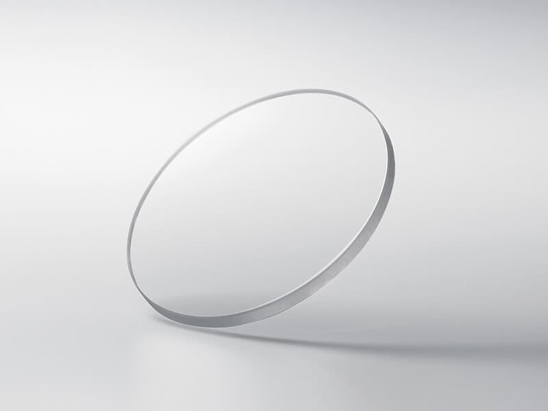 Un disque rond en verre saphir sur un fond gris