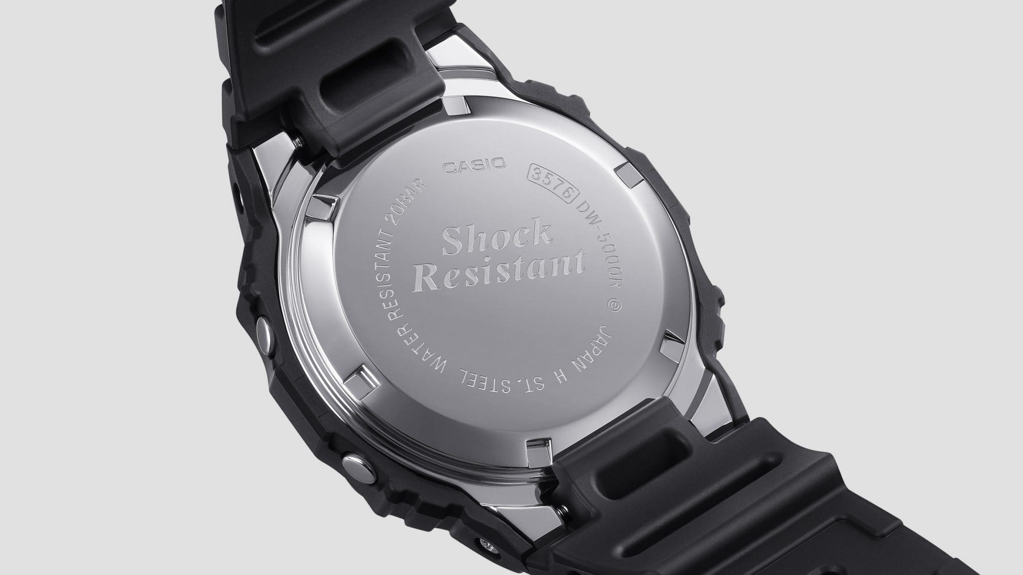 Le dos du boîtier argenté brillant avec gravure : Shock Resistant, Water Resistant 20Bar, St. Steel, 3576 DW-5000 et autres