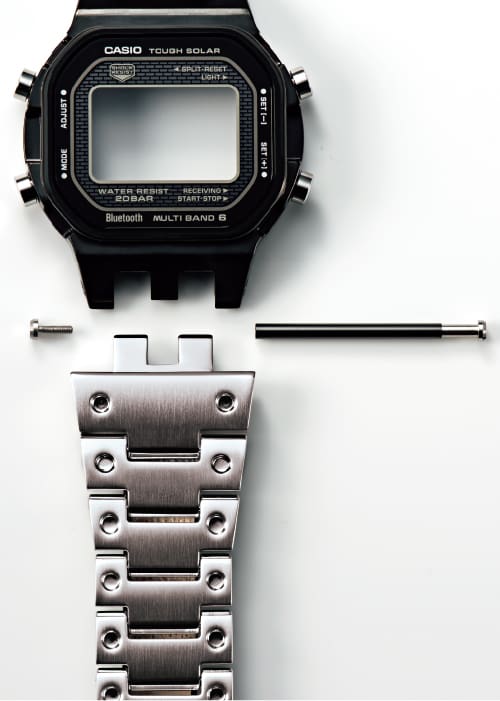 Le boîtier noir, les pièces de liaison et le bracelet à chiffres en acier inoxydable sont positionnés séparément les uns des autres.