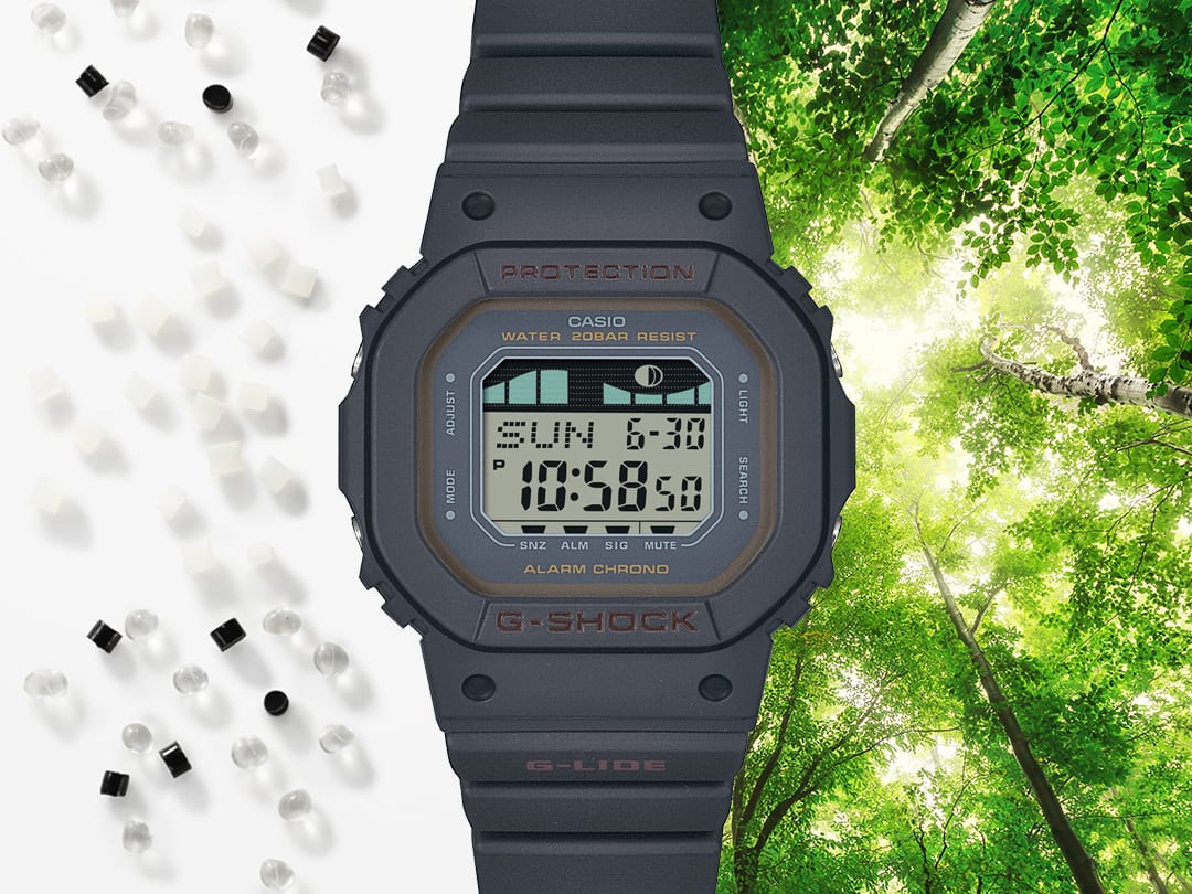 La montre numérique Casio G-Shock GLX-S5600-1 noire entre des grains de résine transparents, blancs et noirs et un feuillage baigné de lumière