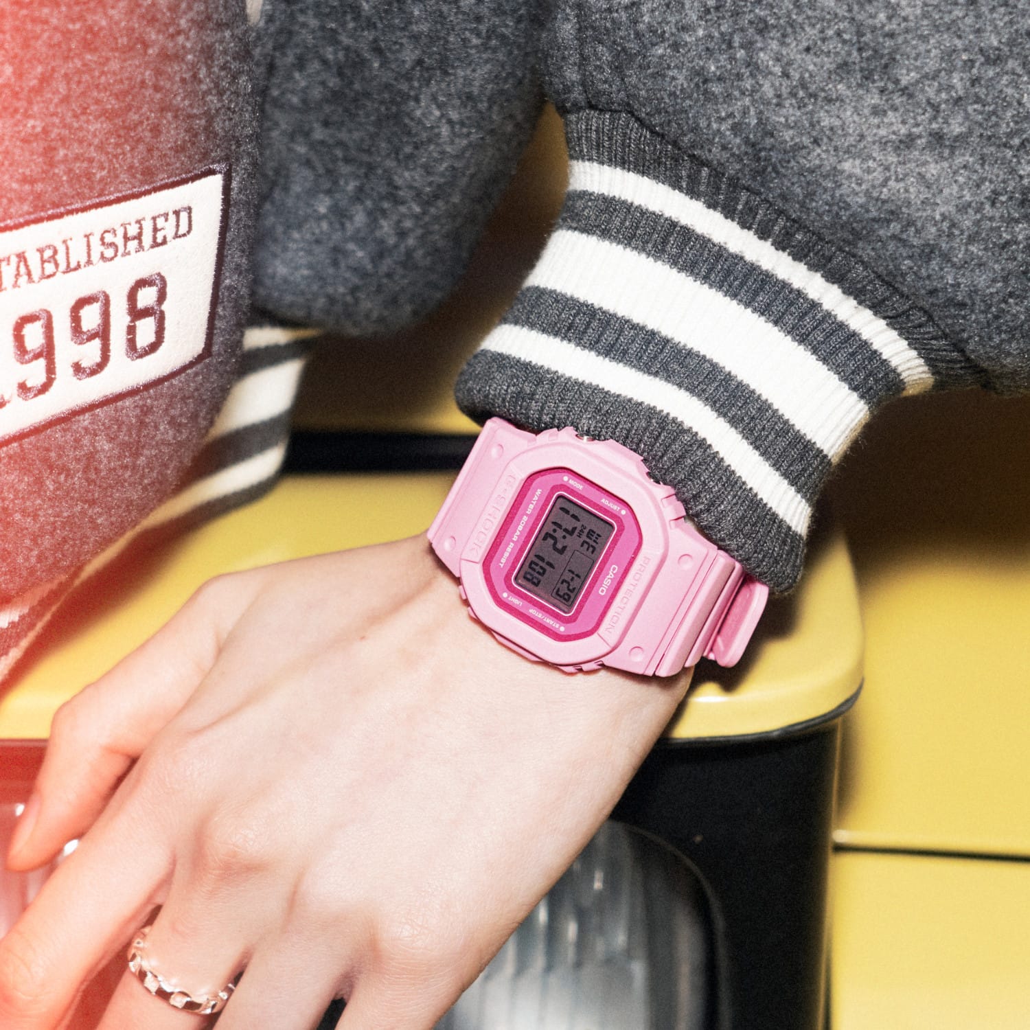 Poignet d'une femme portant la montre numérique GMD-S5610 devant un projecteur.