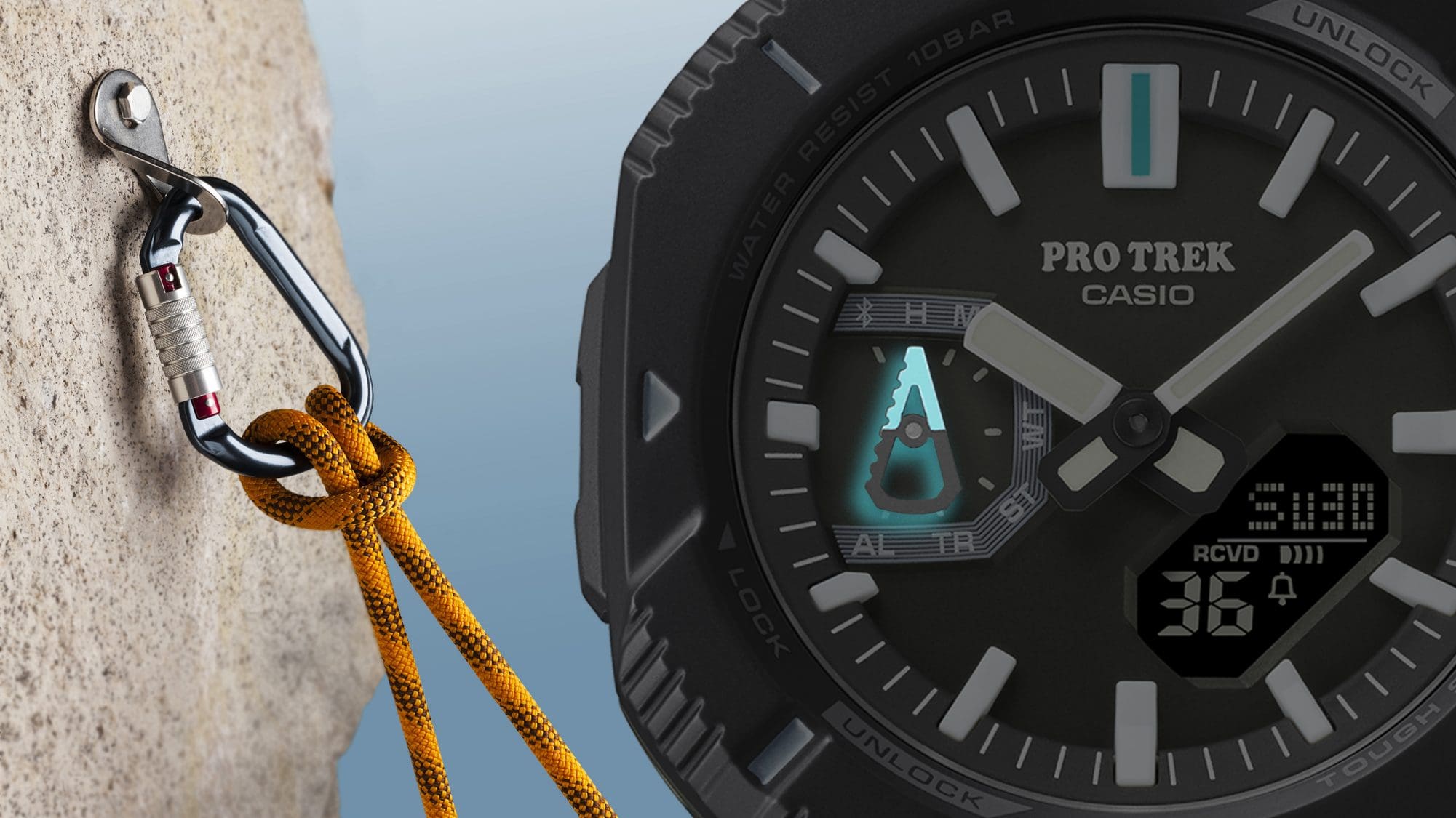 L'écran de la montre d'alpinisme noire PRJ-B001-1 avec aiguilles lumineuses en forme de mousqueton, à côté d'un mousqueton fixé dans la pierre avec une corde de sécurité