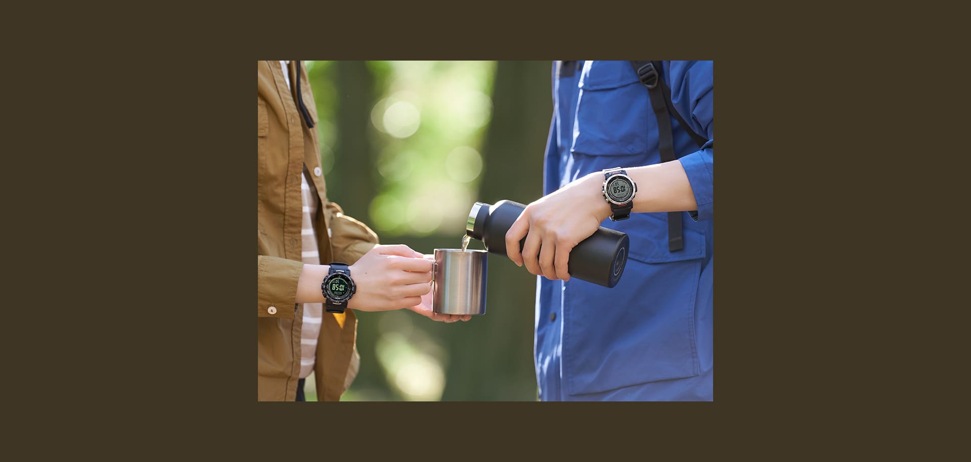 Une personne vêtue d'une veste fonctionnelle bleue verse une boisson dans un gobelet en aluminium à une personne vêtue d'une chemise marron clair à partir d'un thermos. Tous deux portent un modèle PRW-35 au poignet.