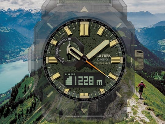 Le cadran analogique-numérique de la montre d'alpinisme PRW-6900Y-3 avec indicateur d'altitude à l'écran, sur fond de sommet verdoyant