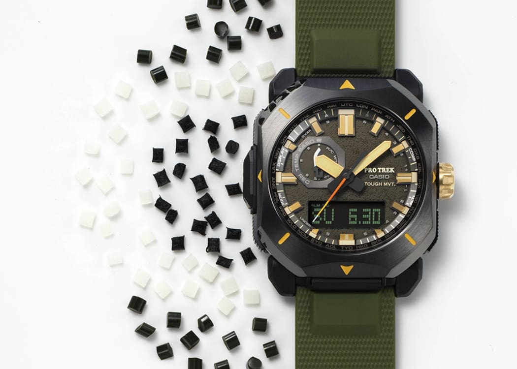 La montre solaire PRW-6900Y-3 avec bracelet en résine synthétique verte à côté de particules de plastique blanc et foncé