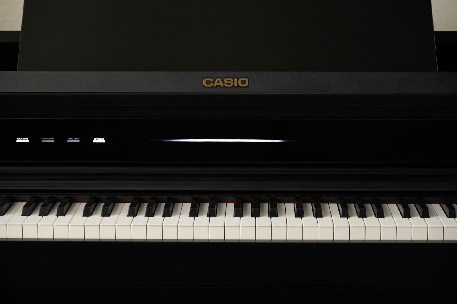 Vue de face du piano numérique noir AP-750 avec couvercle de clavier ouvert et vue sur les touches.