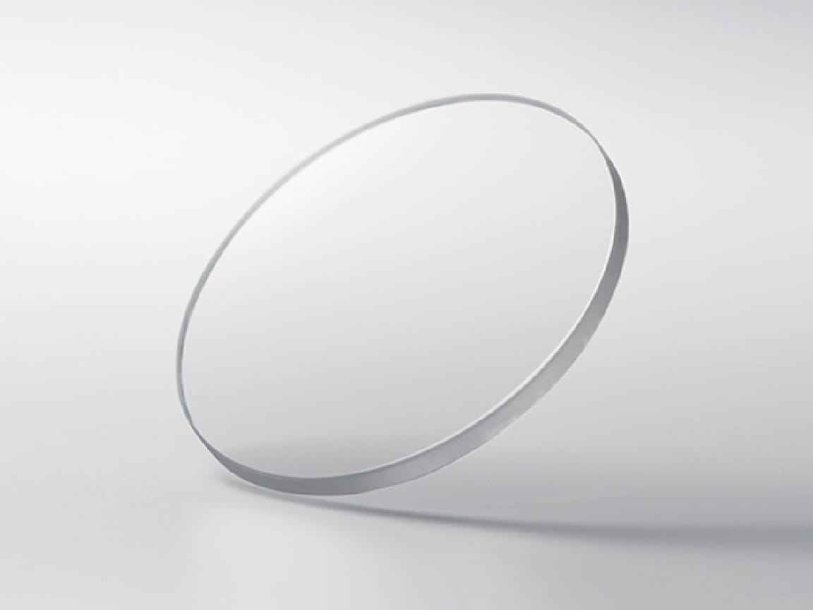 Un disco rotondo in vetro zaffiro su uno sfondo grigio