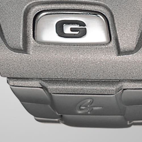 Primo piano della G sulla cassa del Casio G-Shock DW-6900RR-8 nel passaggio al bracciale in acciaio inossidabile