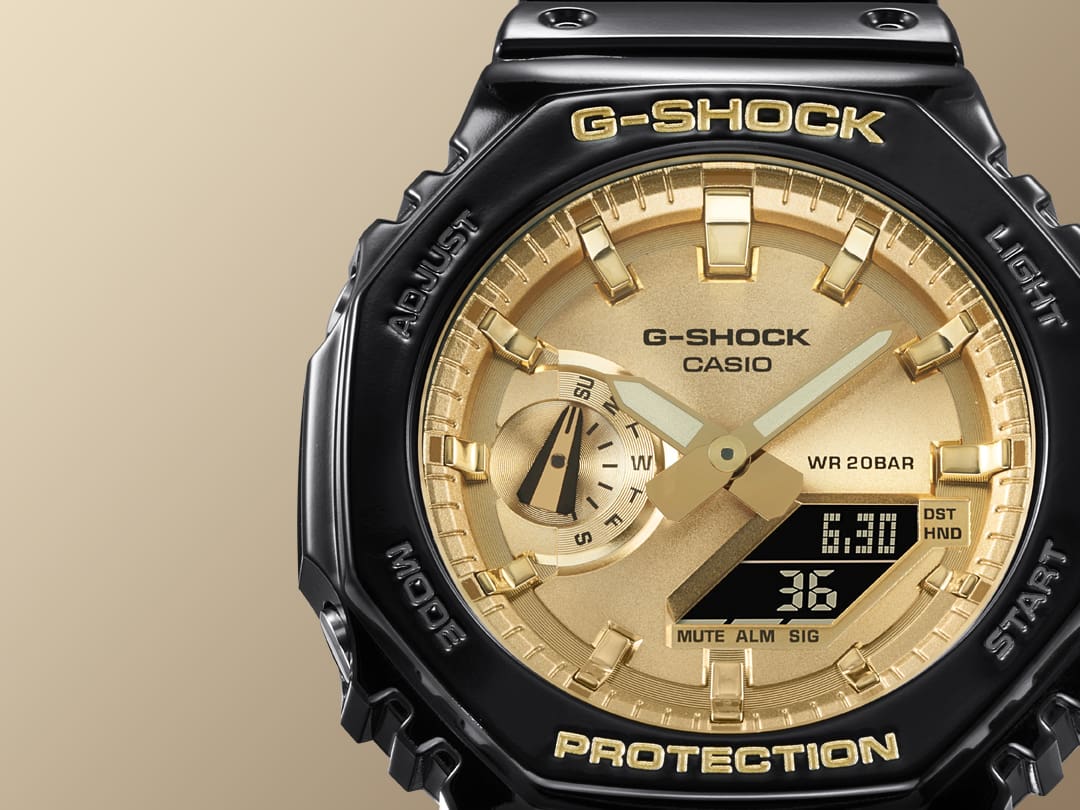 Primo piano del quadrante color oro e della lunetta nera dell' orologio da polso ibrido Casio G-Shock GA-2100GB
