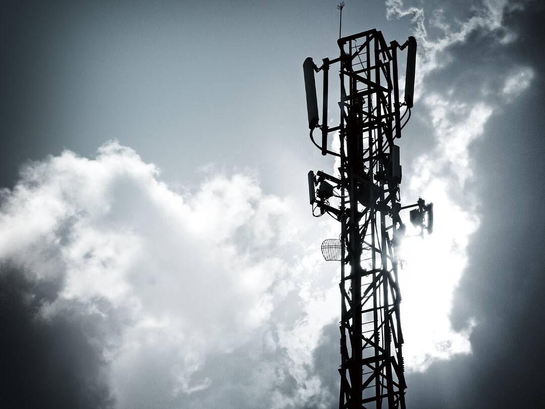 Un'antenna di trasmissione davanti a un cielo nuvoloso