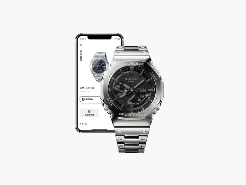 L'orologio ibrido GM-B2100D argento davanti a uno smartphone che visualizza le informazioni sull'orologio