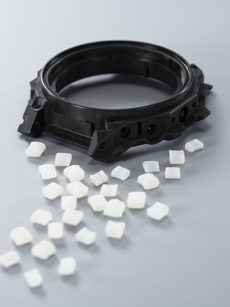 Granuli di resina bio-based accanto alla lunetta dell’orologio GST-B1000.