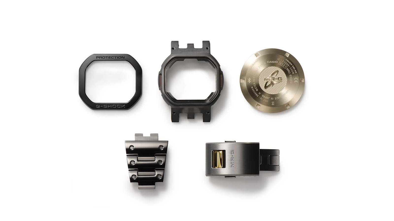 Quelques pièces détachées de la montre en titane MRG-B5000B-1 : lunette, boîtier, dos et maillons du bracelet et fermoir du bracelet