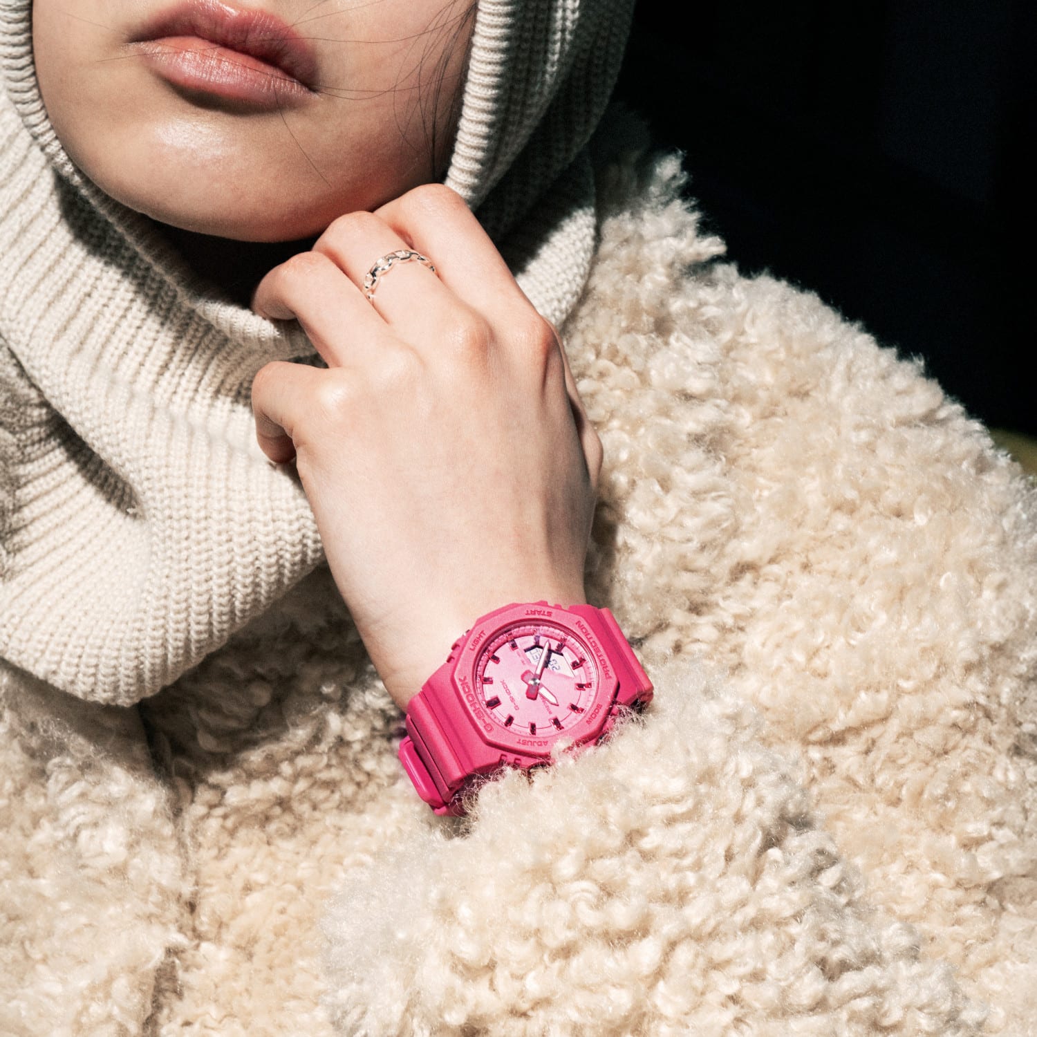 Primo piano di una donna con giacca e passamontagna beige e l'orologio rosa GMA-P2100PP-4 al polso.