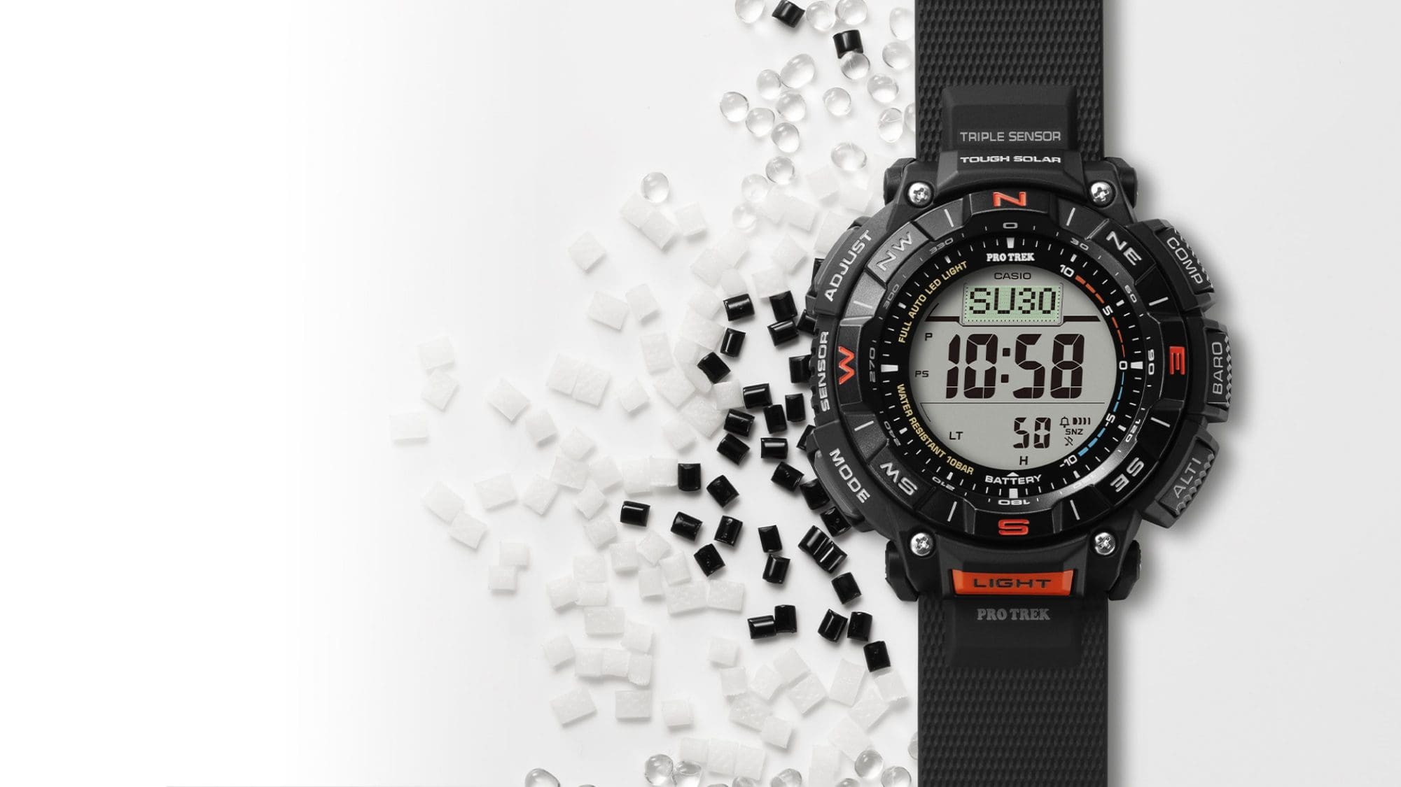 L'orologio multifunzione nero PRG-340-1 accanto a parti in plastica bianca e nera