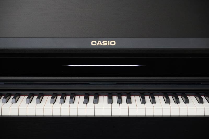 Vista frontale del pianoforte digitale nero AP-550BK con coperchio della tastiera aperto e vista dei tasti