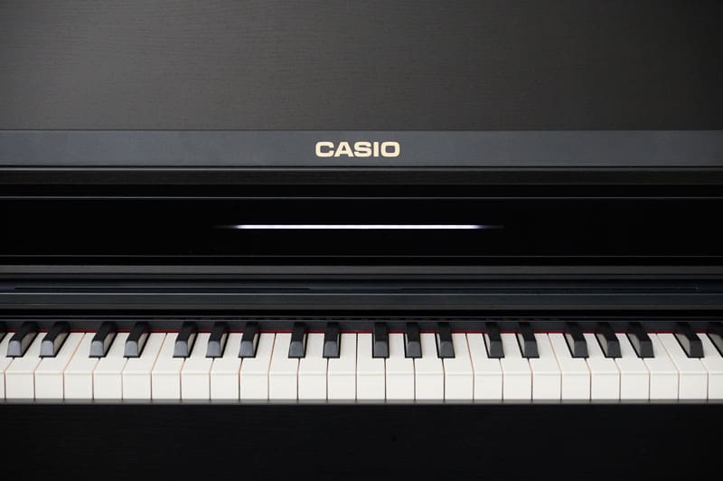 Vista frontale del pianoforte digitale AP-550BK nero con il coperchio della tastiera aperto e una vista dei tasti