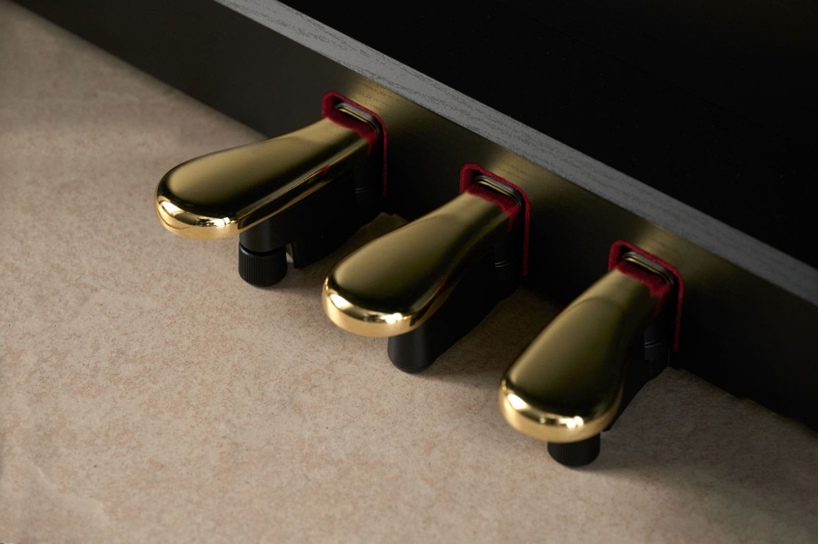 Primo piano dei tre pedali color oro