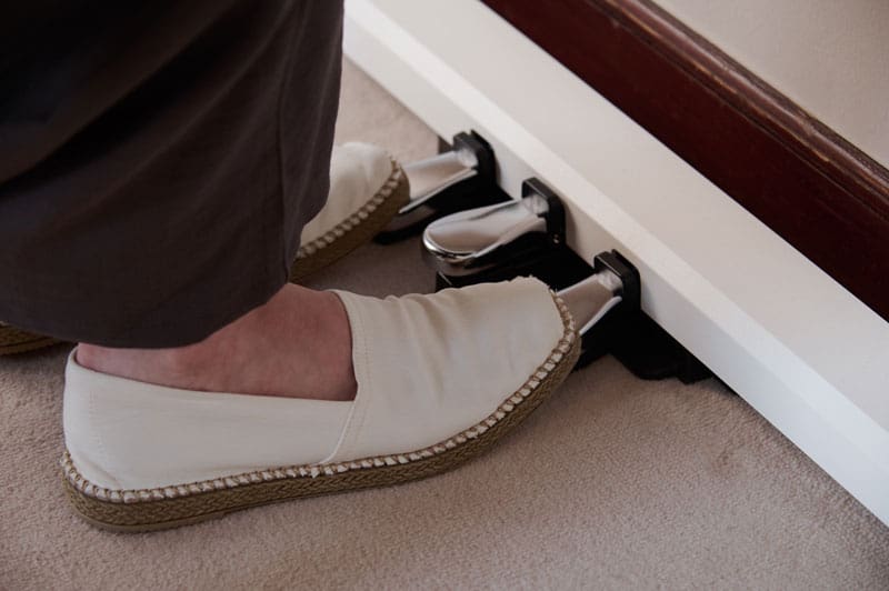 I piedi di due signore in espadrillas chiare azionano i pedali argentati di un pianoforte digitale AP-S200WE bianco