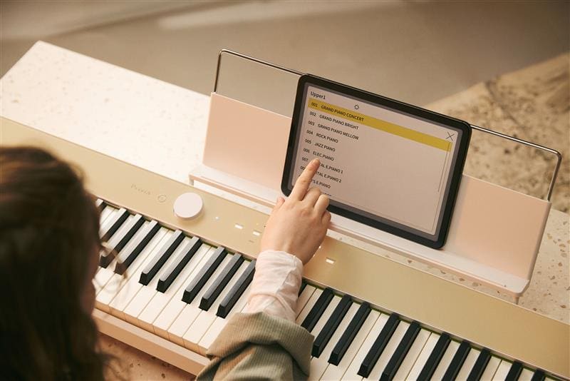 Un'immagine di una persona che utilizza la tavoletta collegata al pianoforte.