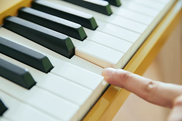 Primo piano della tastiera Privia PX-S7000HM, mentre un dito preme un tasto