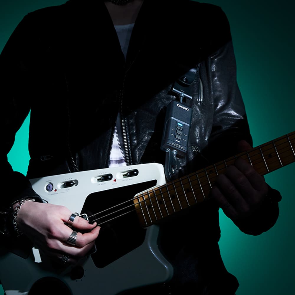 DIMENSION SHIFTERのトランスミッターを取り付けたギターを演奏している写真