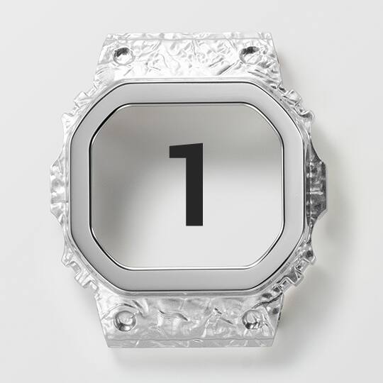 De roestvrijstalen lunette in de eerste nabewerkingsstap, nog steeds zilverkleurig, maar al met een stenen afwerking