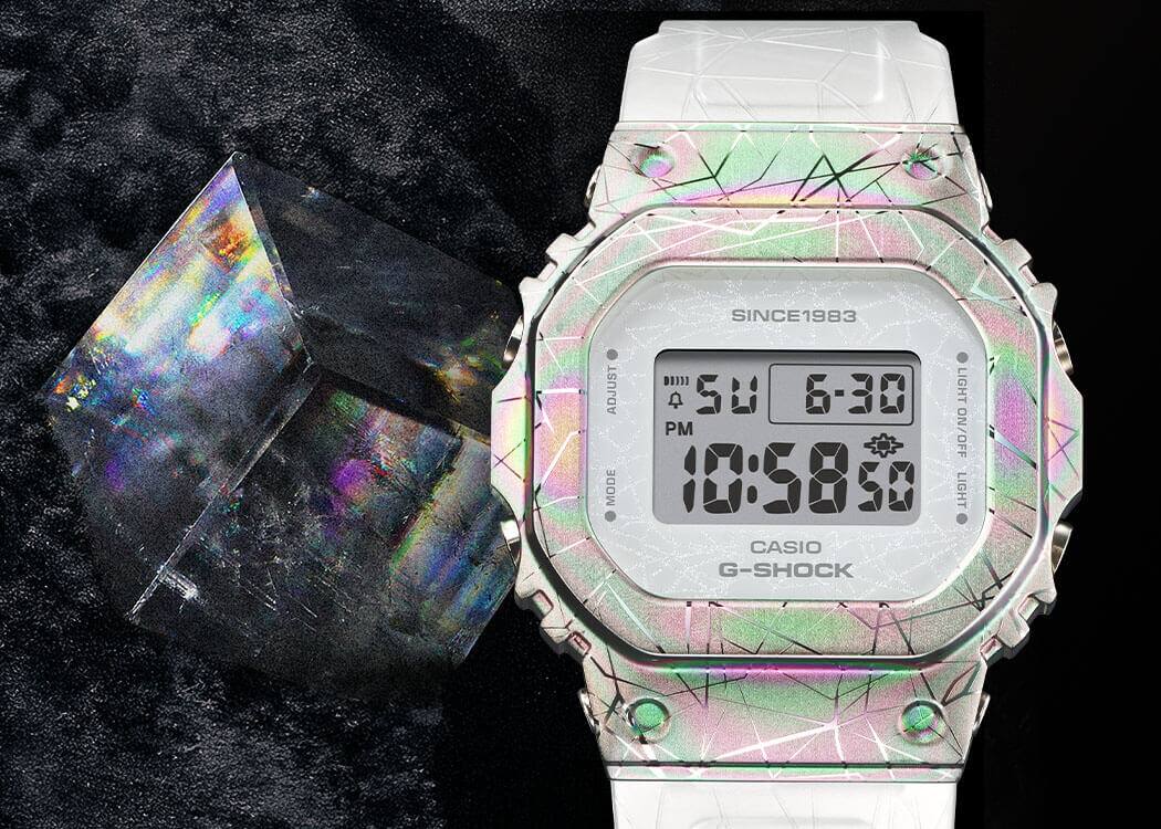 GM-S5640GEM-7 Het glinsterende witte GM-S5640GEM-7 jubileum horloge naast een fonkelend calciet kristal