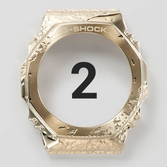 De roestvrijstalen lunette van het GM-S2140GEM-9A polshorloge glanst in zijn gouden afwerking