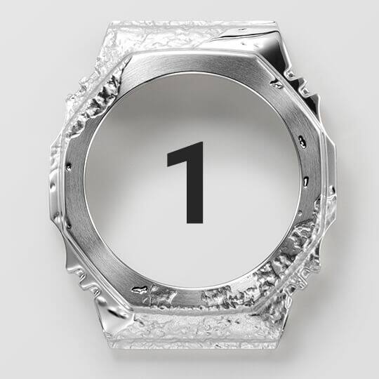 De roestvrijstalen lunette in de eerste afwerkingsstap, nog steeds zilverkleurig maar al met een stenen afwerking