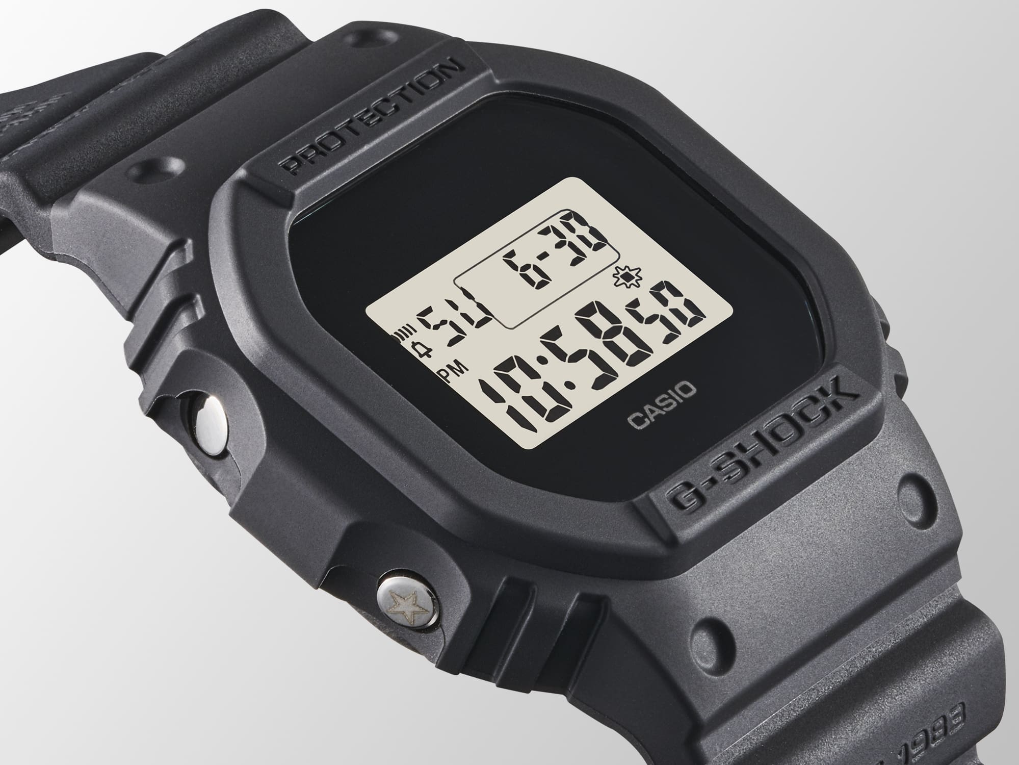 Zijaanzicht van het DWE-5657RE-1 digitale horloge met een blik op de zilverkleurige modusknop met gegraveerde sterren aan de linkerkant van de kast