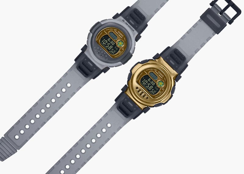 De twee ontwerpen van het Casio G-Shock G-B001MVB polshorloge naast elkaar: één met een grijs-transparante urethaan bezel en één zonder, zodat de goudkleurige metalen bezel volledig zichtbaar is.