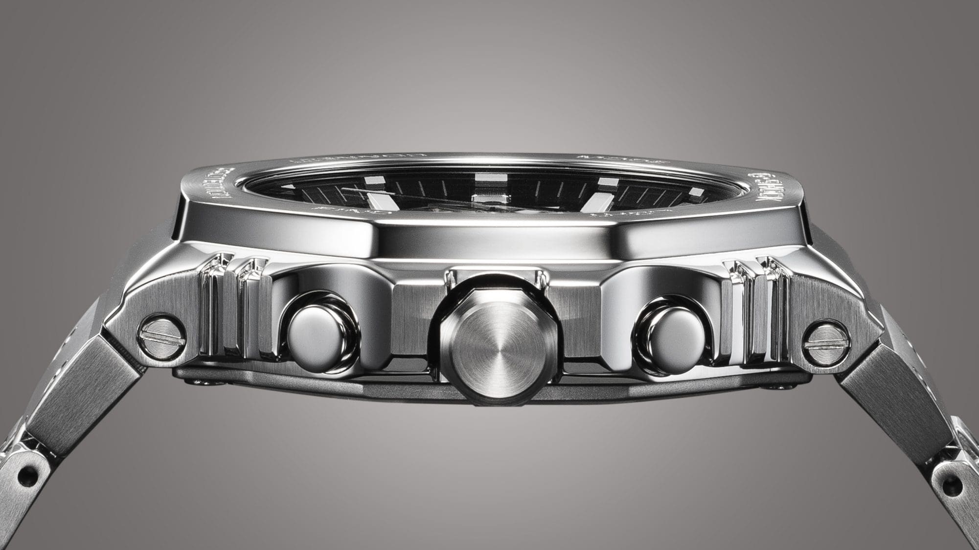 Zijdelings zicht op de slanke, zilverkleurige kast van een Casio G-Shock GMC-B2100 full metal horloge met zijn knoppen en schroeven