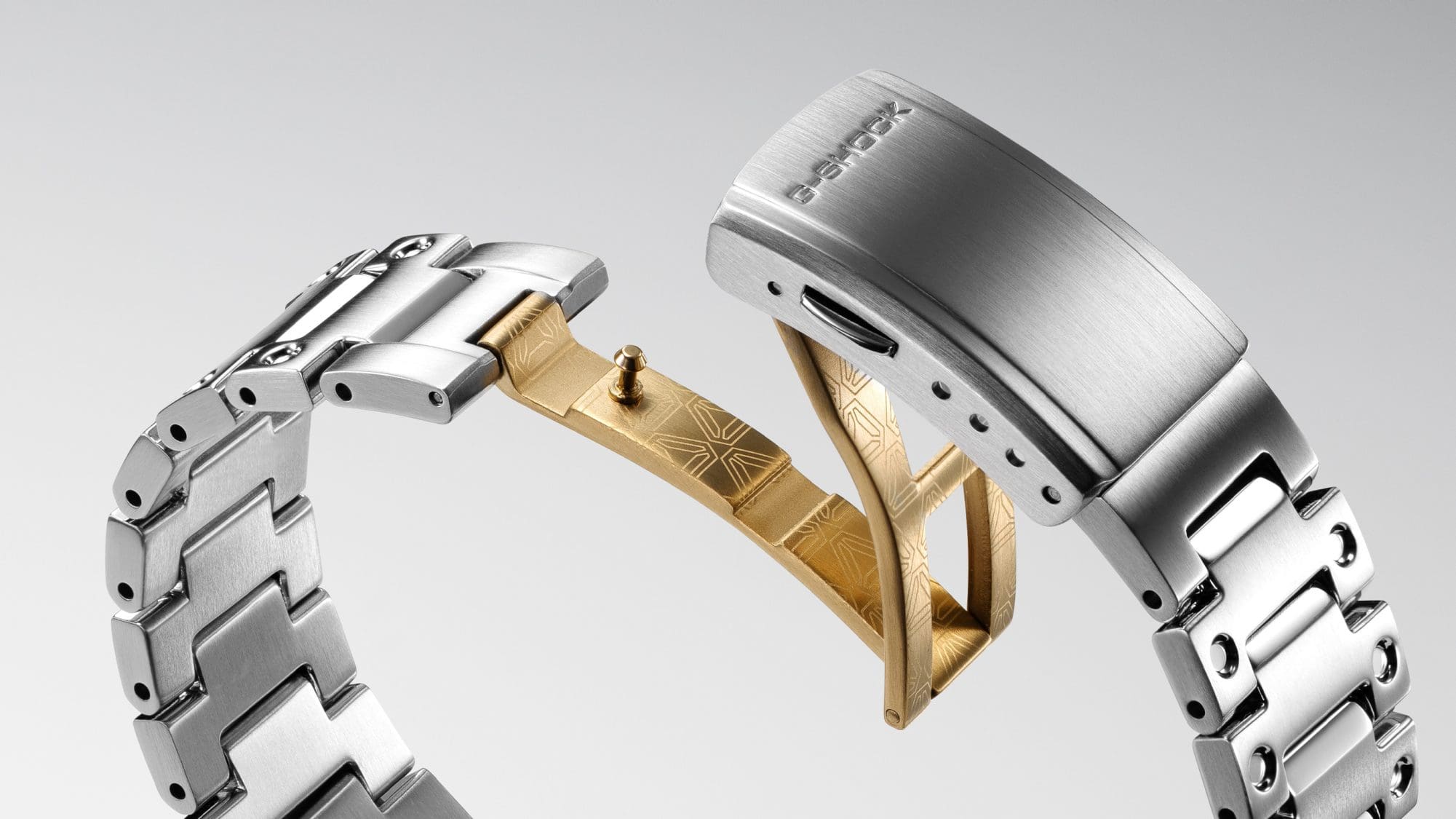 Detailopname van de speciale Casio G-Shock GMW-B5000SS armbandsluiting in goud en zilver