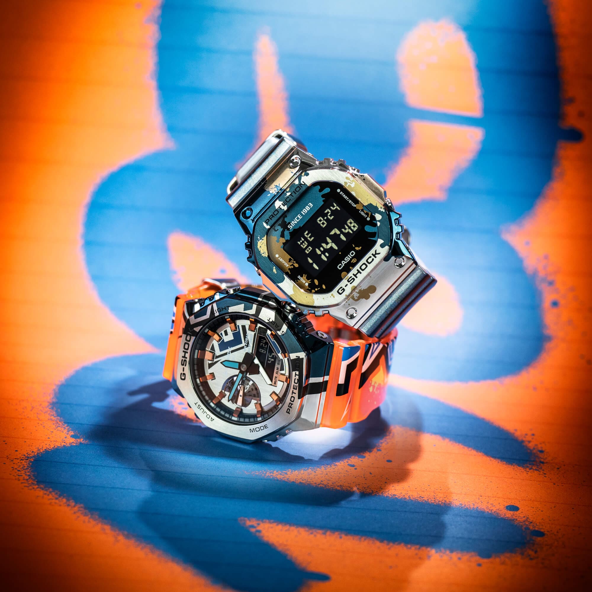 Product afbeelding van de GM-2100SS-1ER en de GM-5600SS-1ER van G-SHOCK op een graffiti achtergrond.